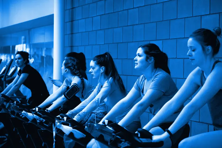 Clase de spinning con varias personas pedaleando